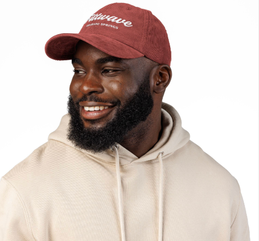 man wearing rust-colored Fittwave hat / cap with beige hoodie. athletic cap.
