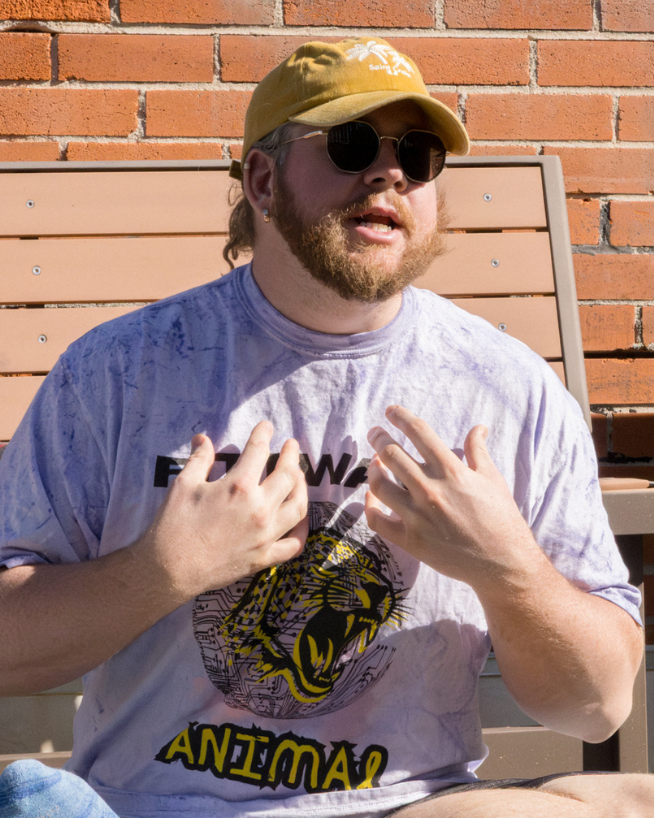 Purple tee with yellow lettering by Fittwave worn by man in sunglasses outside at a workout in Colorado Springs, Colorado